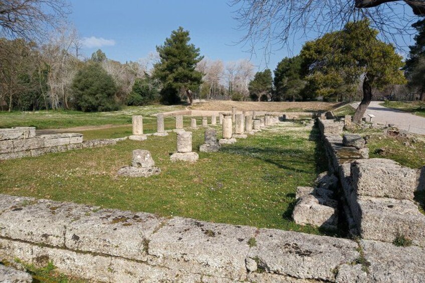 Ancient stone ruins with columns and a stone wall in a park. 3