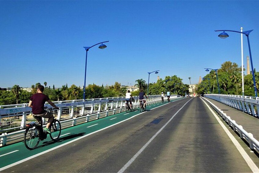A bridge with a bike lane, metal railings, and street lamps. 2