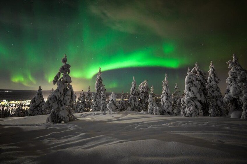 A snowy landscape with snow-covered trees and the Northern Lights. 4