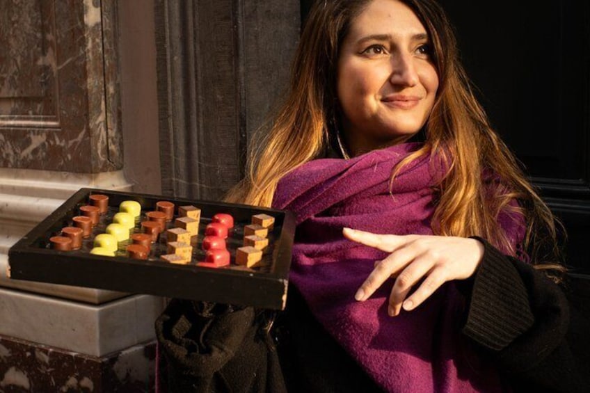 A person holding a tray of assorted chocolates. 1
