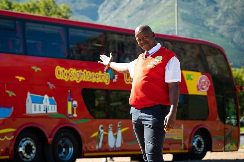 A man standing in front of a colorful bus with 'CitySightseeing' written on it. 2
