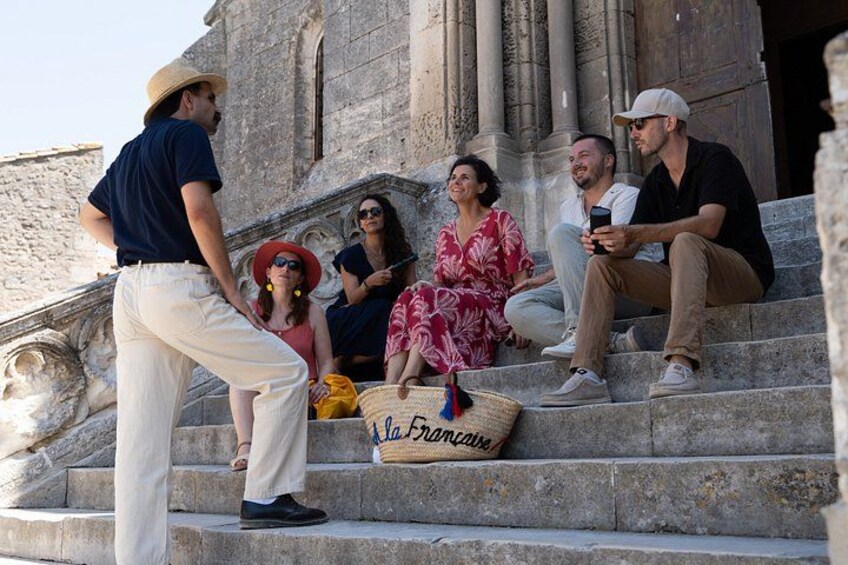 A group of people sitting on stone steps in front of a building with columns. 3