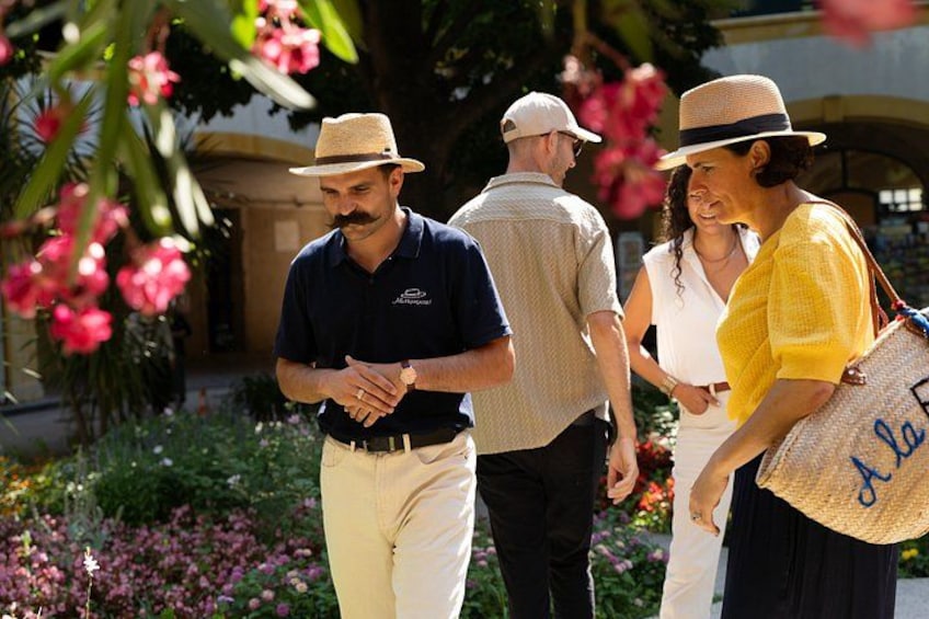 A group of people walking in a garden with flowers and plants. 5