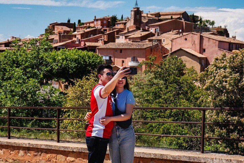 Una pareja tomando una foto con un pintoresco pueblo de fondo. 2