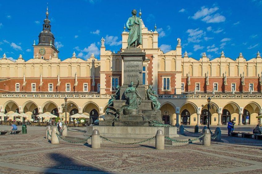 A historic building with a statue in the center, surrounded by an open plaza with arches. 2