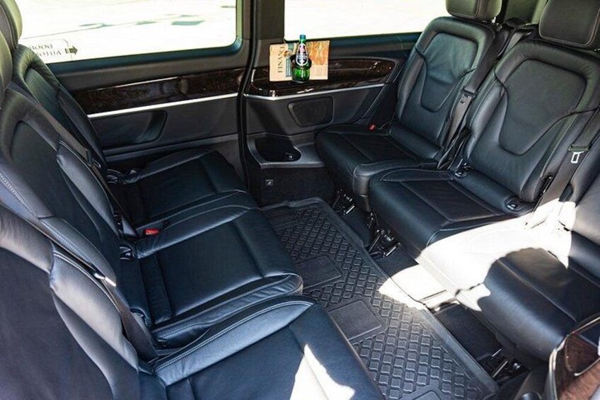 A vehicle interior with black leather seats, a center console, and a rear view mirror. 4