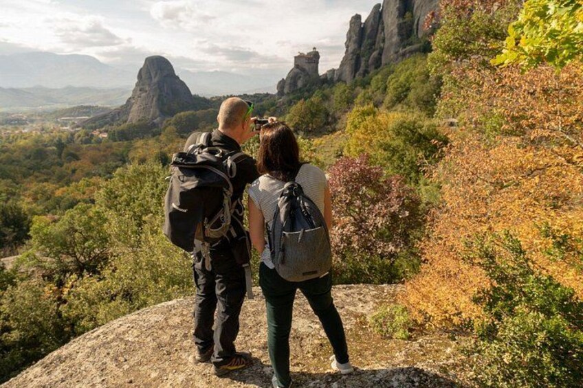 Deux personnes font de la randonnée sur un terrain rocheux, avec un paysage montagneux en arrière-plan. 2