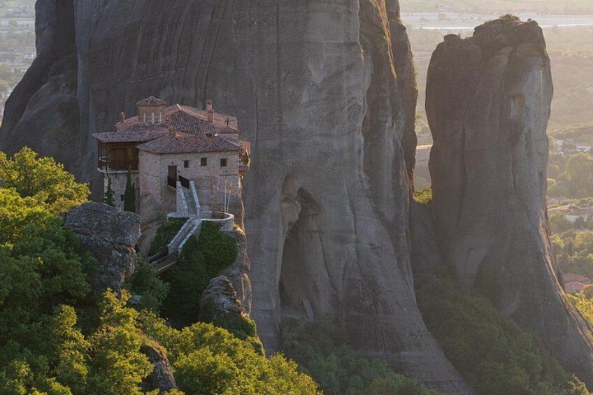 A building perched on a cliff with a waterfall. 3