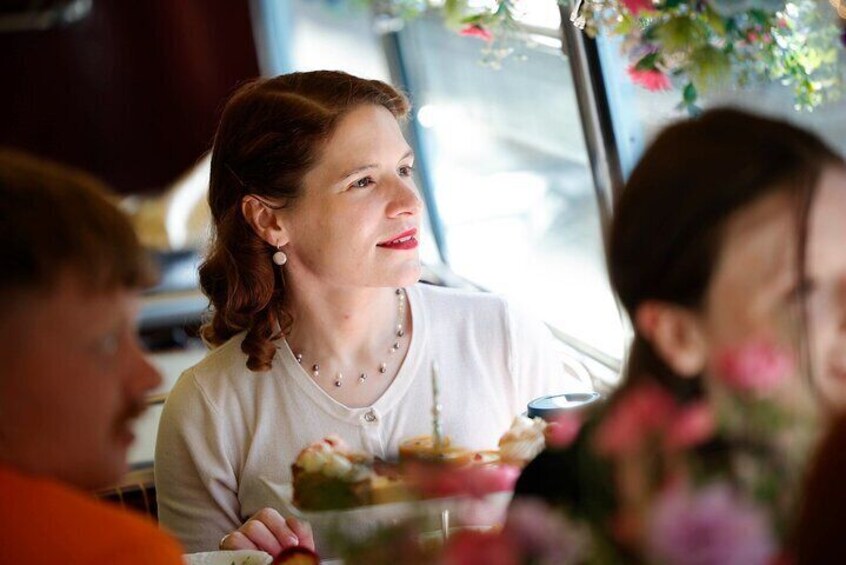 A person sitting at a table with a glass of water and a plate of food. 2