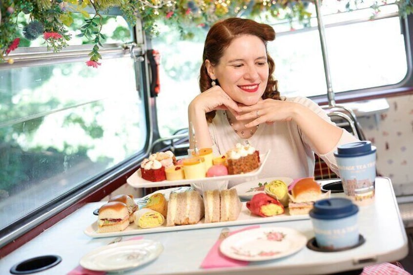 A person sitting at a table with various food items and a drink. 1