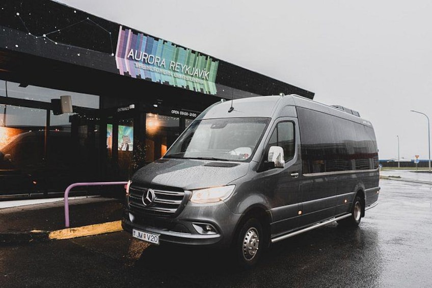 A grey Mercedes-Benz van parked in front of a building with a colorful awning that reads 'AURORA REYKAVIK.' 2