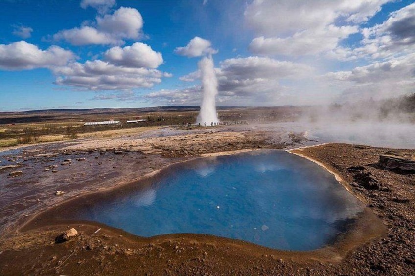 En gejser, en varm kilde og en klar, blå pool i et naturligt landskab. 2
