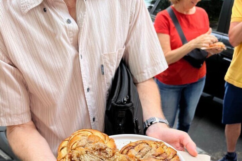 A person holding a plate with pastries. 2