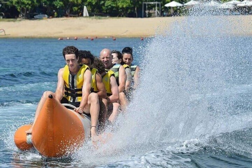 People on a watercraft with a beach in the background. 2