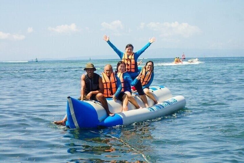 A group of people on a blue and white inflatable raft in the ocean. 3