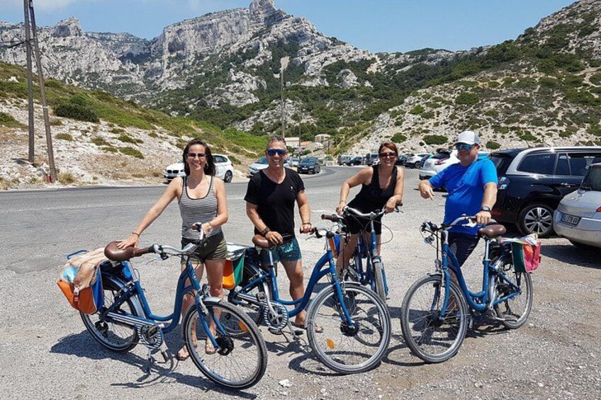 Four people on bicycles in a parking lot with rocky mountains in the background. 3