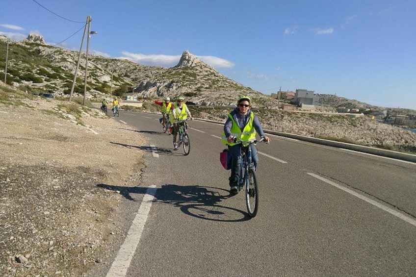 Cyclists on a road with rocky terrain and a clear sky. 2