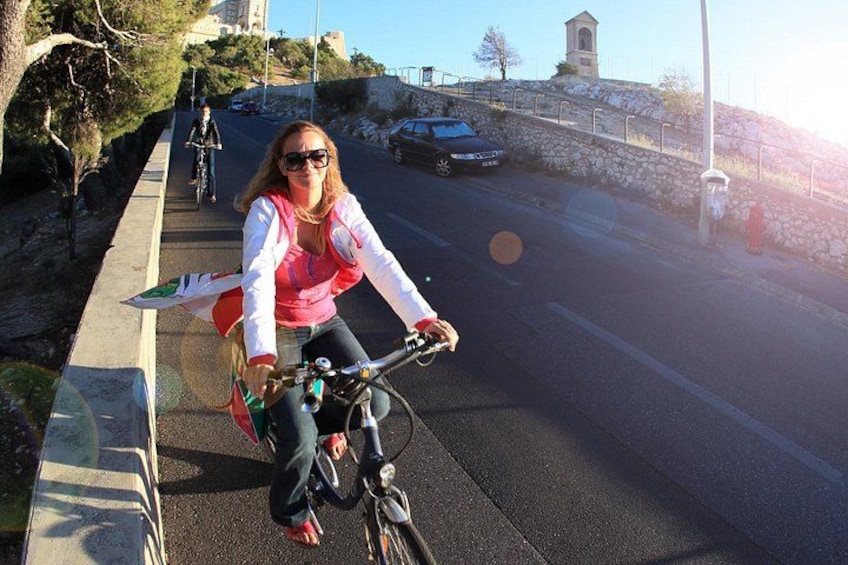 A person riding a bicycle on a paved path alongside a road. 5