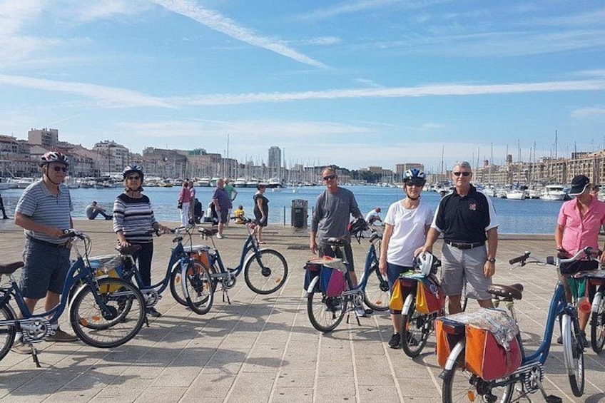 A group of people standing with bicycles on a waterfront promenade. 4