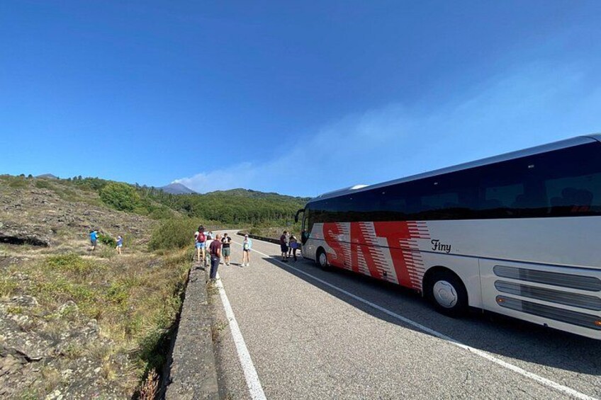 Ein Bus auf einer Straße, neben dem Menschen hergehen. 2