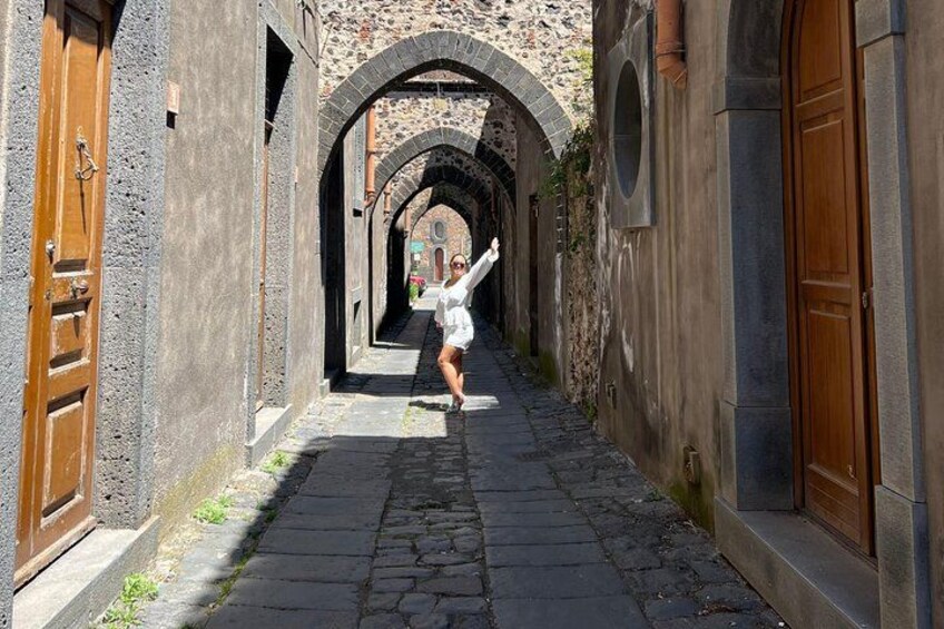 A narrow alleyway with stone walls and wooden doors. 2