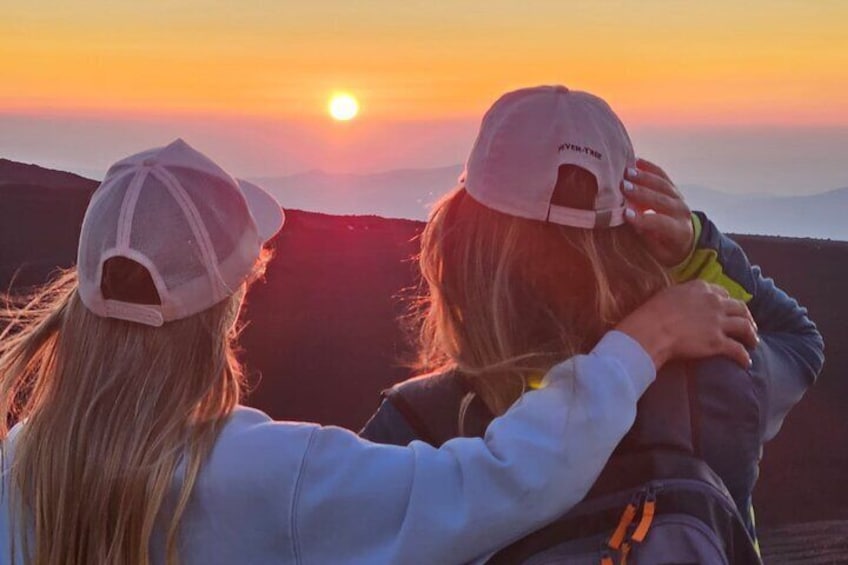 Two people embracing at sunset with the sun visible in the background. 1