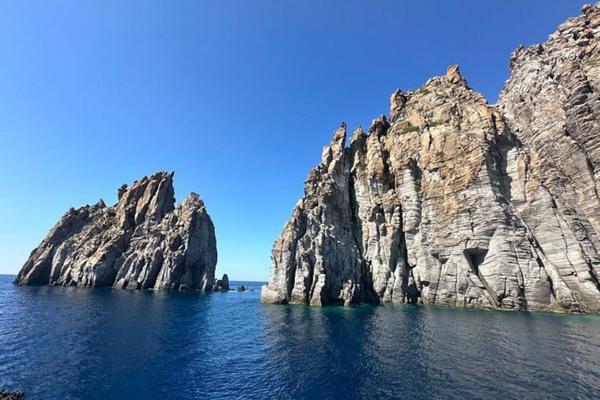 Une formation rocheuse côtière bordée d’une eau d’un bleu limpide. 5