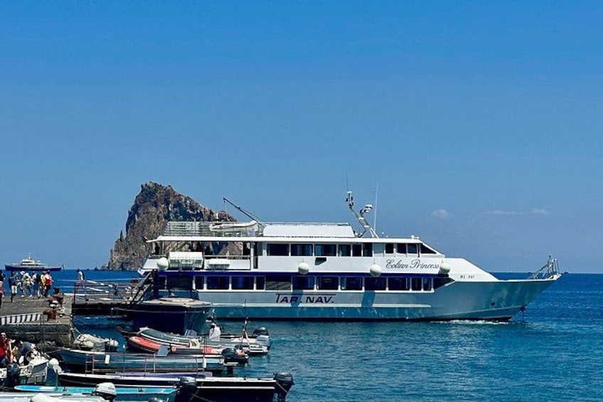 Un grand traversier baptisé « Eden Princess » accosta à un quai, non loin duquel se trouvaient de plus petits bateaux, et une île rocheuse se dressait à l’arrière-plan. 2