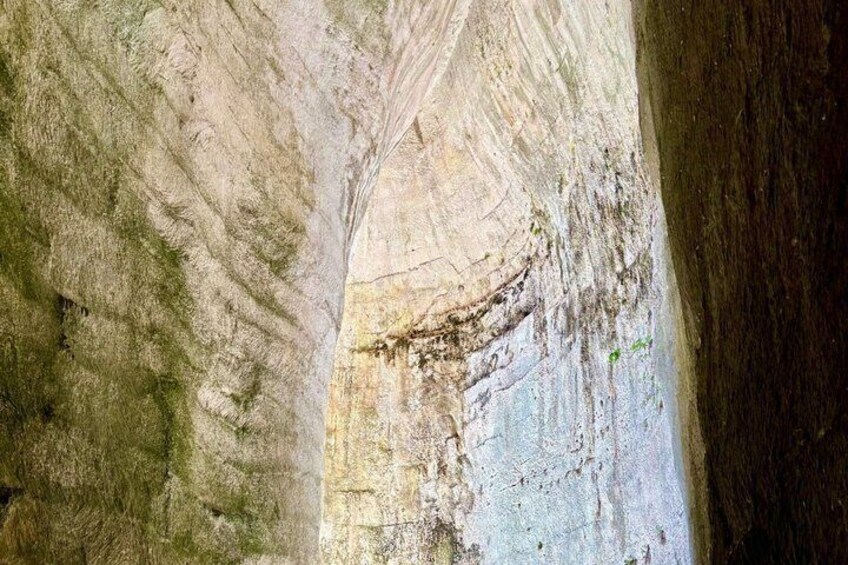 A cave interior with stalactites and a narrow passageway. 3