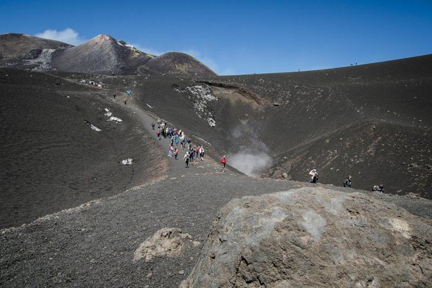 Paisaje volcánico con un grupo de excursionistas en un sendero. 3