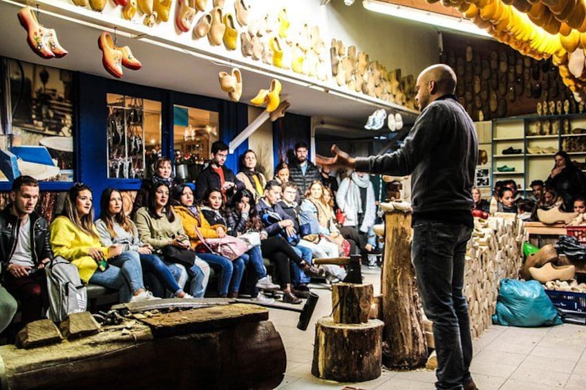 A man standing in a shoe store surrounded by a crowd of people. 3
