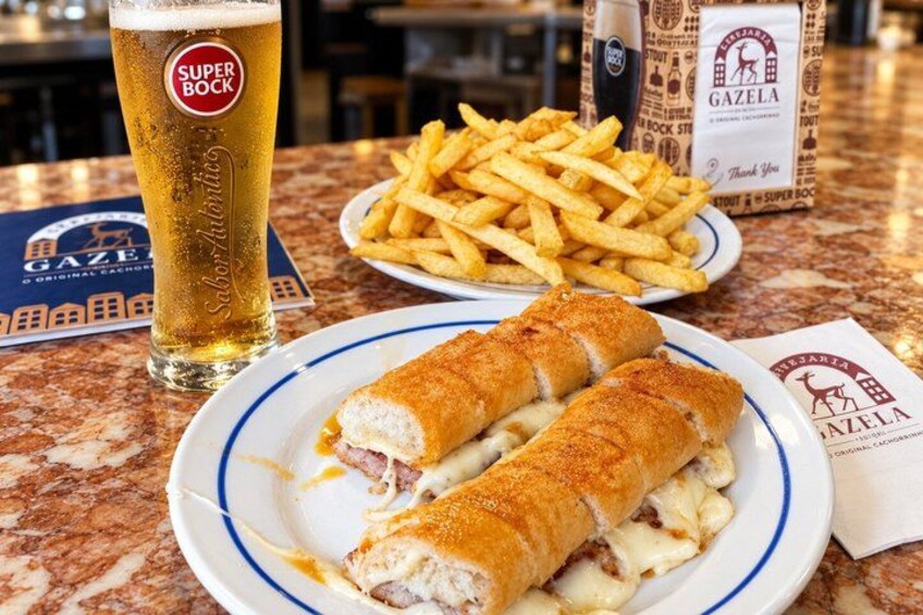 A meal with a sandwich, fries, and a beer on a table. 3