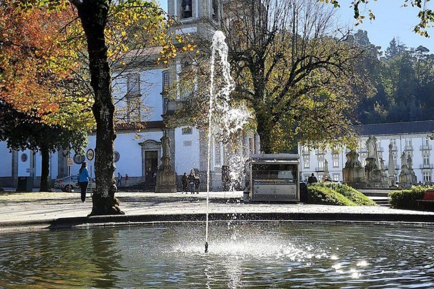 A fountain in a park with a building in the background. 4