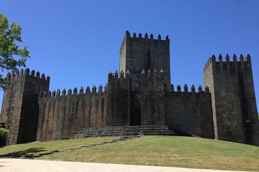 A medieval castle with tall, crenellated towers and a central entrance. 1