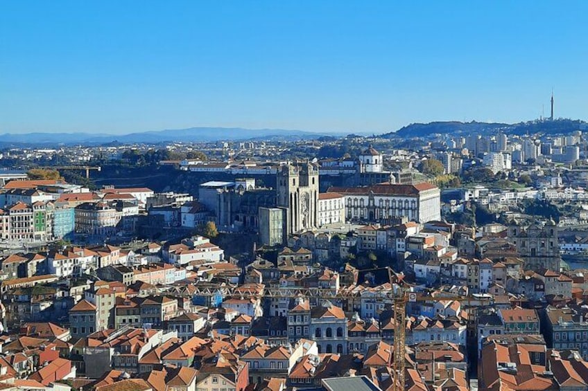 A cityscape with a prominent cathedral, dense urban buildings, and a distant hill. 3