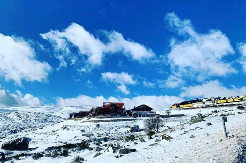 A snowy landscape with a building and a yellow structure. 4