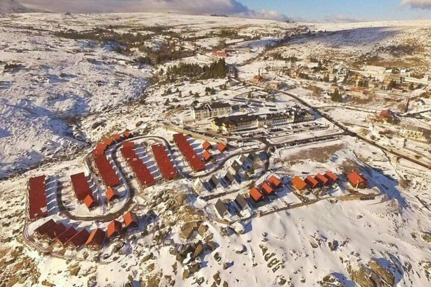 A snow-covered landscape with a large, winding structure resembling a roller coaster. 5