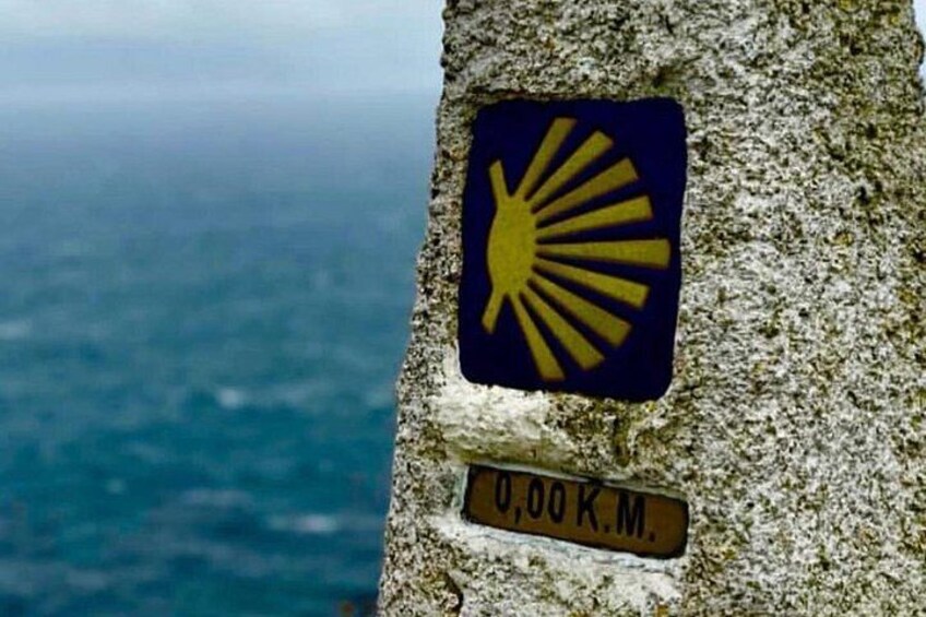 A sign with a sun symbol and a distance marker of 0.00 km. 5