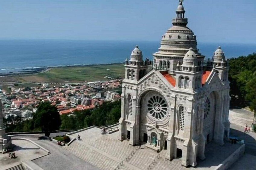 A large cathedral with a dome and arched windows, overlooking a coastal town. 3