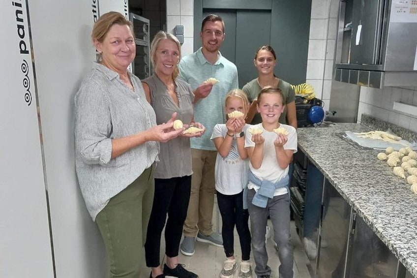 Un gruppo di persone in cucina tiene in mano dell'impasto. 2