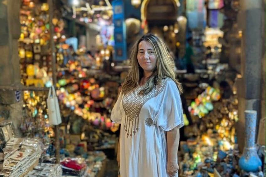 Una persona in un mercato con diversi articoli in mostra. 1