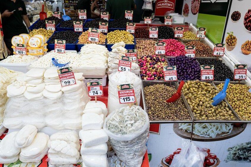 Un étal de marché proposant une variété de fruits secs et de noix, notamment des amandes, des noix et des abricots secs, avec des étiquettes indiquant les prix. 2