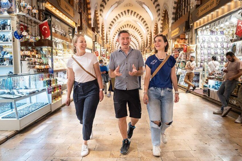 A shopping street with people walking, shops on either side, and a tiled floor. 2