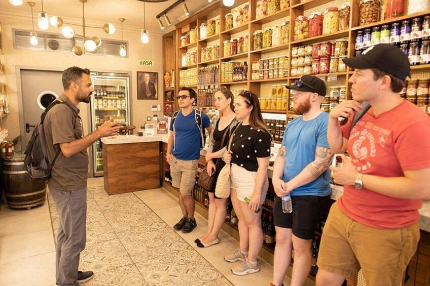 Een groep mensen in een winkel met schappen vol producten en een balie. 2