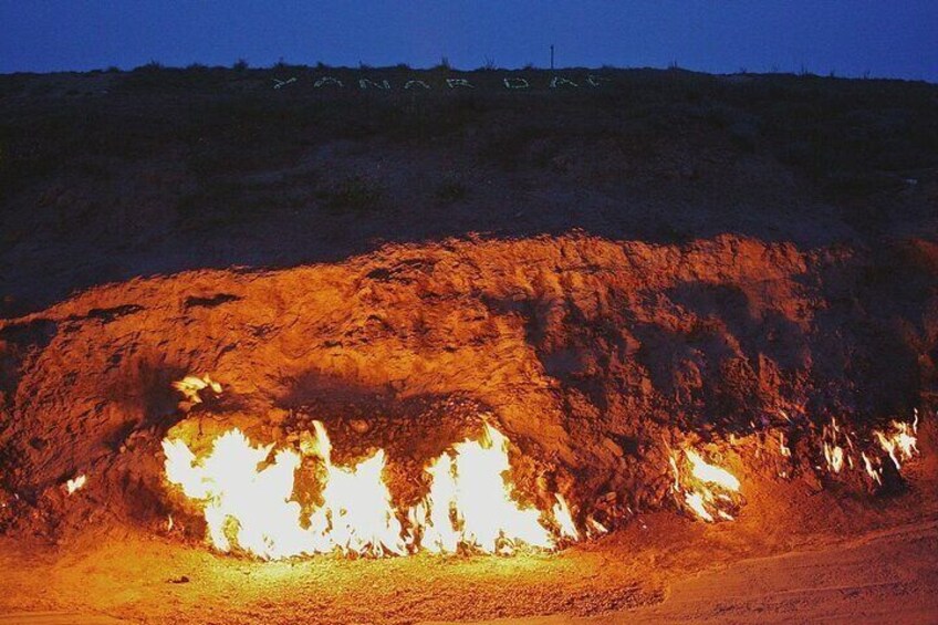 A large, illuminated rock formation at night. 5