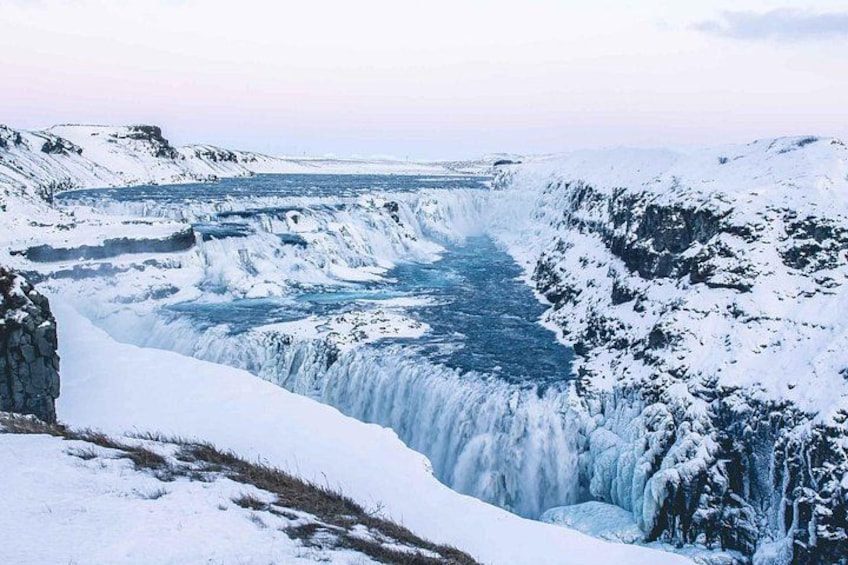 Una cascata coperta di neve in una zona montuosa. 2