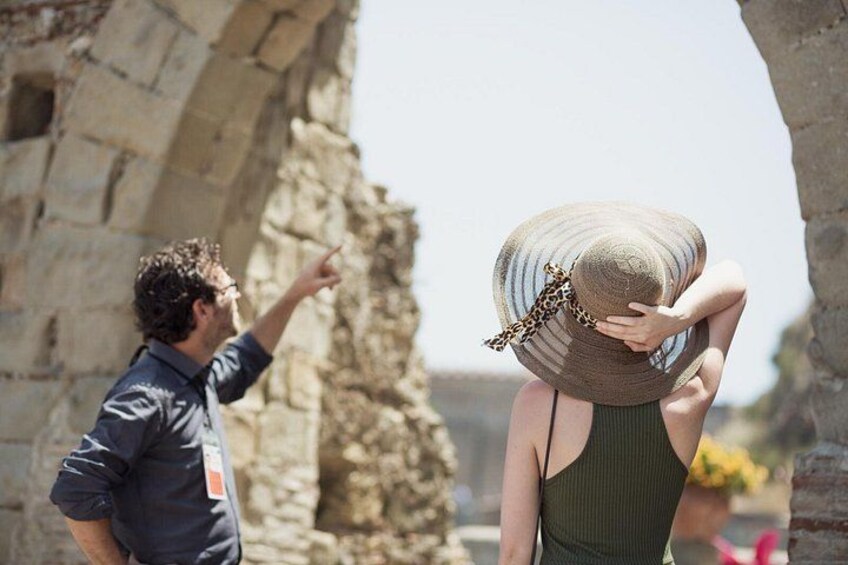 A person pointing at an ancient stone structure. 2