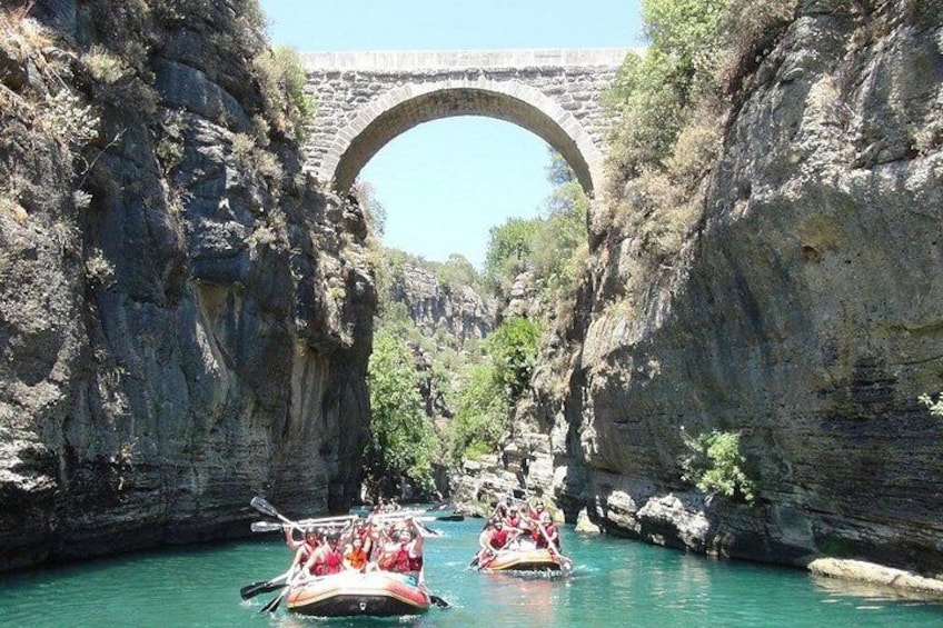 Un río con barcos, un puente de piedra y acantilados rocosos. 4