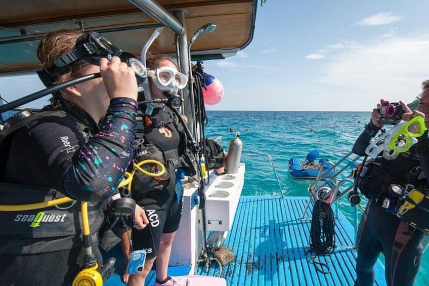 A group of scuba divers on a boat preparing for a dive. 5