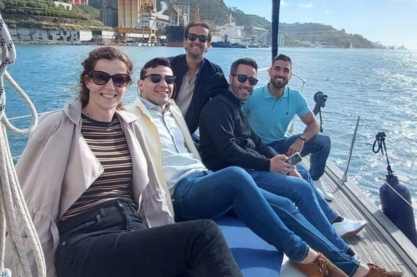 A group of people on a boat with a body of water and buildings in the background. 2